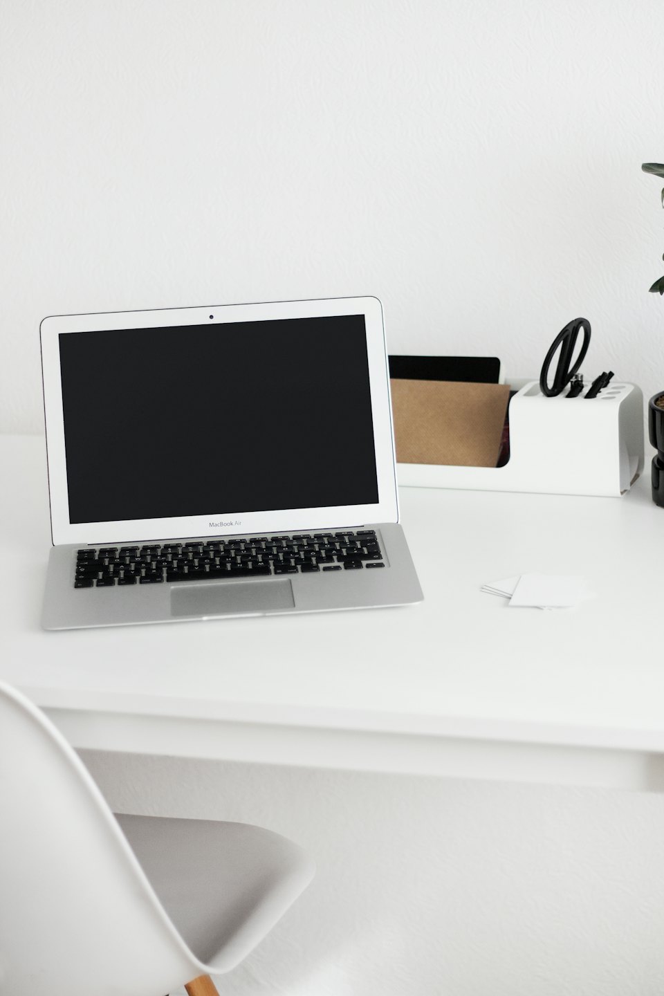 Laptop and desk organizer on a white desk.